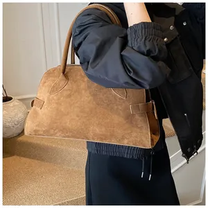 Detalle del bolso tote marrón mate grande con hebilla lateral y textura retro elegante