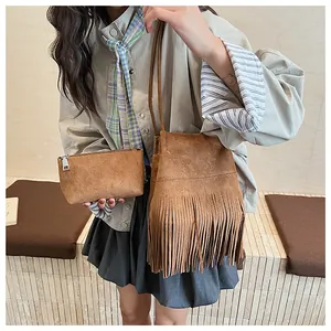 Detalle de bolso saco de ante retro con flecos y un bolso de mano pequeño a juego