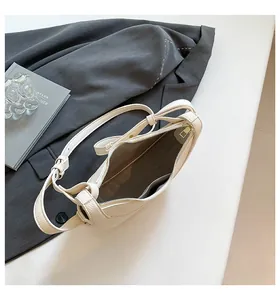 Vue de dessus du sac croissant beige montrant la poche intérieure et la doublure