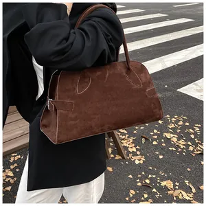 Detalle de costura en forma de hoja y hebilla en un bolso tote de ante marrón retro