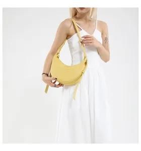 Détail montrant la texture du cuir jaune vif et la sangle réglable du sac croissant