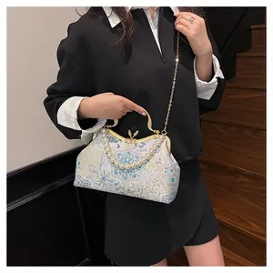 Close-up of vintage floral jacquard bag with pearl handle and golden chain strap