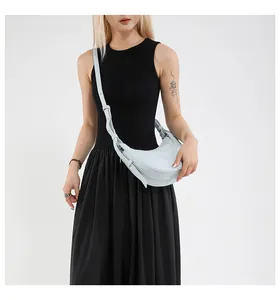 Détail du sac bandoulière croissant bleu clair avec bandoulière décorative nouée