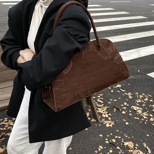 Bolso tote grande de ante marrón para mujer mostrado en un elegante entorno otoñal