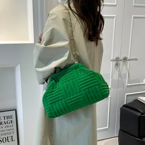 Bolso de hombro con cadena y textura verde con gabardina beige para la moda de 2025