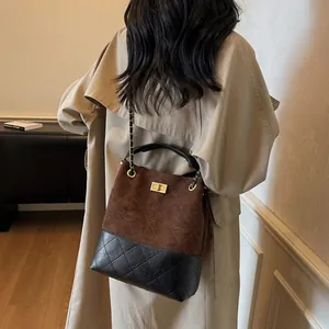 Bolso cubo vintage acolchado con cadena dorada y diseño bicolor mostrado en modelo