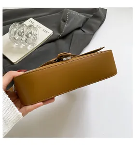 Détails du sac à bandoulière marron montrant la boucle latérale et les coutures précises