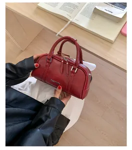Detalle del bolso Boston rojo oscuro con cremalleras plateadas dobles y el logo PANTOOR metálico