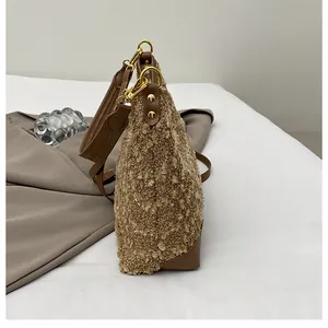 Detalle de la textura de felpa marrón y la hebilla metálica dorada en el bolso de mujer
