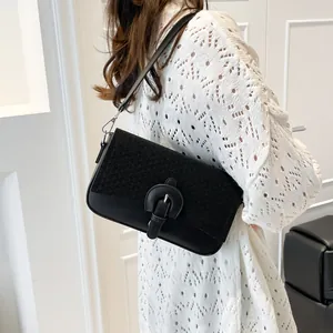 Sac à épaule rétro noir en tweed et cuir patchwork porté par un mannequin
