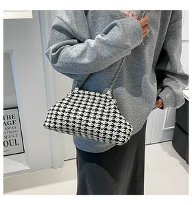 Detalle de bolso vintage de pata de gallo con cadena y cierre de clip plateado