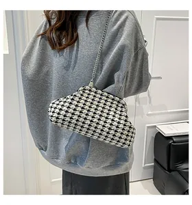 Detalle del bolso de pata de gallo con cadena metálica y cierre retro de clip
