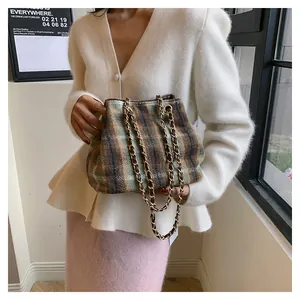 Detail of British style checkered bucket bag with dual chain straps and wool fabric