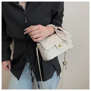 Détail du sac beige matelassé avec foulard en soie élégant et fermoir rotatif doré