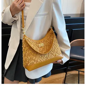 Detalle de bolso de tweed amarillo mostaza con cierre giratorio dorado y ribetes de cuero liso