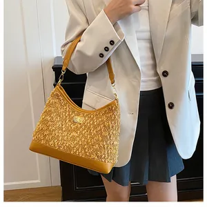 Detalle macro de bolso bandolera de tweed amarillo jengibre con cierre giratorio metálico