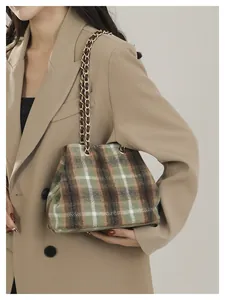 Detail shot of the British style vintage plaid bucket bag with a metal chain strap