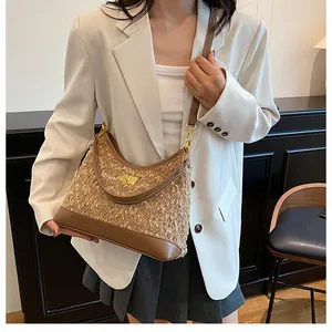 Detalle del bolso de tweed camel con base de cuero marrón y cierre de giro dorado brillante