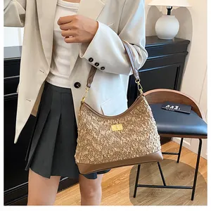 Primer plano del bolso de hombro con contraste de texturas y cierre metálico dorado