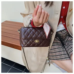 Détail du sac à bandoulière marron foncé surpiqué avec poignée foulard et fermoir doré