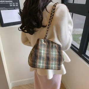 British vintage plaid bucket bag with gold chain strap shown on a model's shoulder
