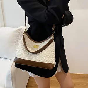 Bolso de hombro vintage de borreguito con cierre dorado y ribete de cuero marrón
