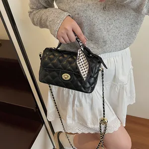Sac à main matelassé noir avec chaîne dorée et détail de foulard en soie chic