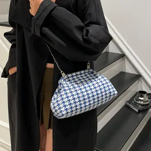 Bolso nube de pata de gallo azul y blanco con cadena plateada combinado con abrigo negro