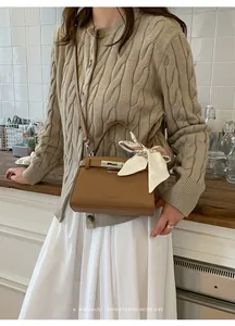 Bolso de piel marrón con detalle de pañuelo de seda y cierre metálico retro