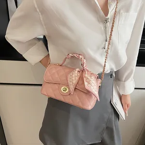 Sac à main matelassé rose avec bandoulière chaîne dorée et poignée ornée d'un foulard