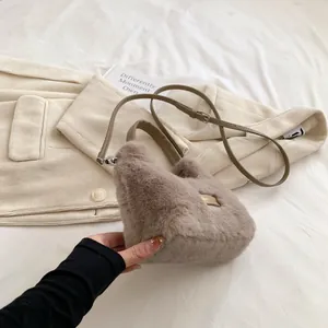 Vue détaillée du sac à main en fausse fourrure avec plaque 'love' et bandoulière en cuir