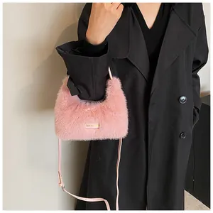Gros plan d'un sac à main en fausse fourrure rose avec bandoulière en cuir