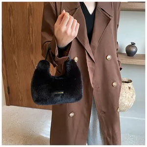 Détail du sac à main en fausse fourrure noire avec étiquette love every day et poignées