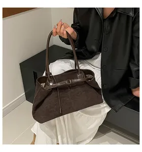Detalle del bolso tote marrón oscuro mate con hebilla metálica y textura de gamuza suave
