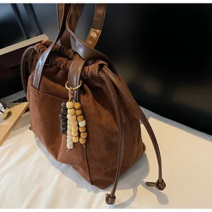 Primer plano del bolso tote de ante café mate con cuentas de madera y correa de cuero