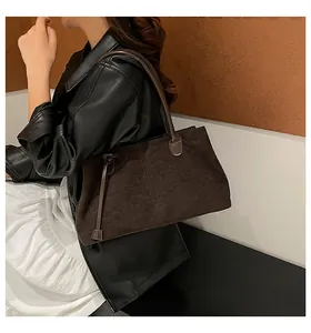 Primer plano del bolso tote de ante café oscuro con textura suave y costuras finas