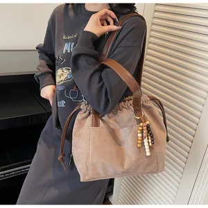 Detalle del bolso tote retro con cordón, textura mate y asas de cuero marrón