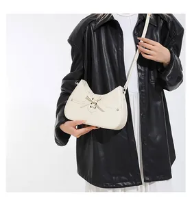 Detail of off-white crossbody bag with unique corset-style lace-up design and metal eyelets