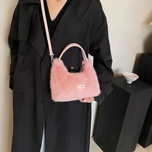 Sac à main en fausse fourrure rose porté par un mannequin en trench-coat noir chic