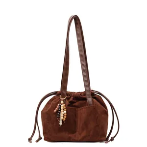 Bolso tote retro marrón oscuro en ante mate con cierre de cordón y colgante de madera