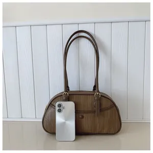 Gros plan sur la texture du cuir synthétique marron et la boucle en métal rétro