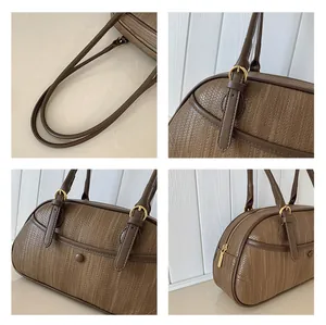 Détails du sac à main marron tissé montrant la boucle dorée et la fermeture à glissière
