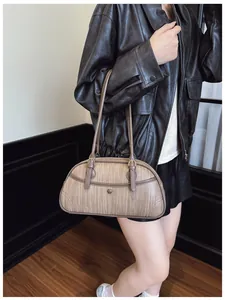 Détail du sac bandoulière tissé kaki avec boucle ronde en métal et finitions en cuir