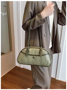 Détail du sac à main tissé vert foncé vintage avec finitions en cuir et forme de lune
