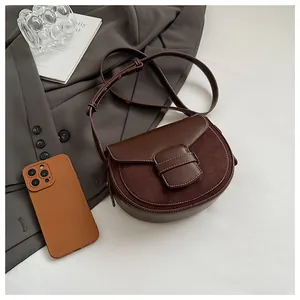 Primer plano de un bolso de silla marrón oscuro con textura de cuero mate sobre blazer