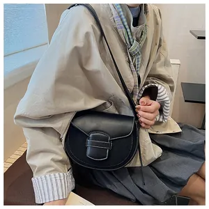 Detalle del bolso de silla negro mate con costuras blancas en contraste y solapa imán