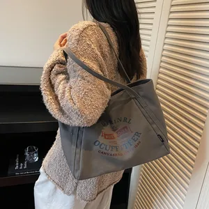 Bolso tote de lona gris con letras vintage en un ambiente interior elegante