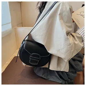 Detalle del bolso de silla negro con costuras blancas en contraste y hebilla