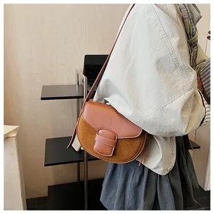 Detalle del bolso de hombro marrón mate con costuras blancas y correa fina elegante