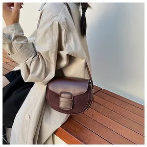 Detalle de bolso montura marrón oscuro con diseño de retazos en cuero liso y ante